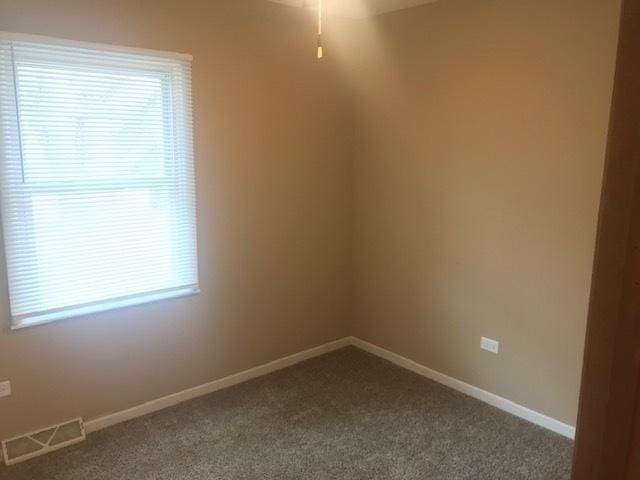 carpeted empty room with visible vents and baseboards