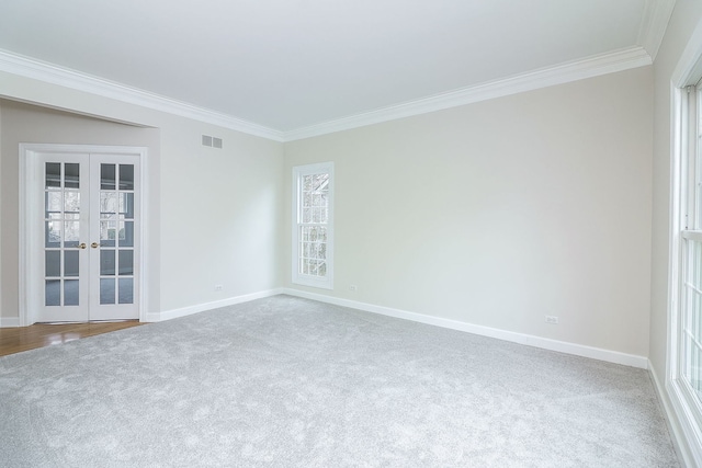 unfurnished room with crown molding, french doors, and carpet