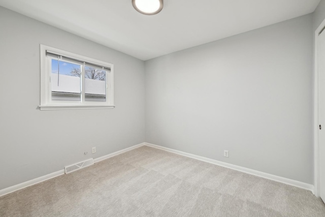 spare room featuring light colored carpet