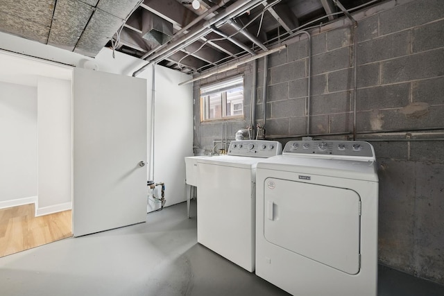 clothes washing area with washer and dryer and sink