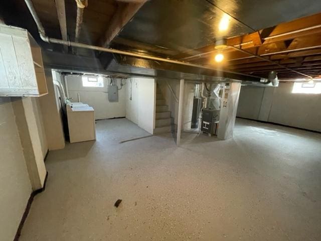 below grade area with washer / clothes dryer, electric panel, and stairs