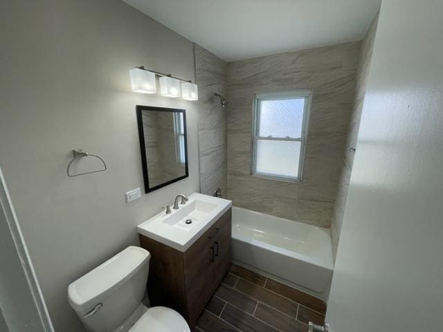 bathroom featuring toilet, vanity, and bathing tub / shower combination