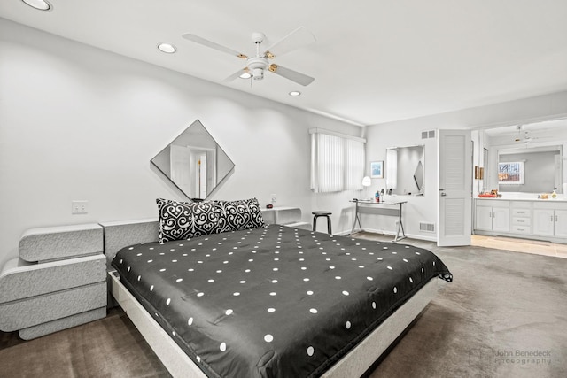 carpeted bedroom with ceiling fan and ensuite bath