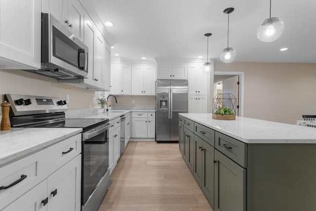 kitchen with white cabinetry, light hardwood / wood-style flooring, a kitchen island, and appliances with stainless steel finishes