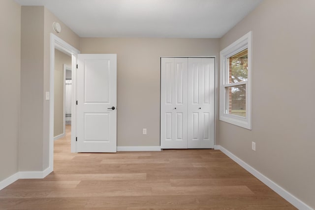 unfurnished bedroom featuring light hardwood / wood-style flooring and a closet