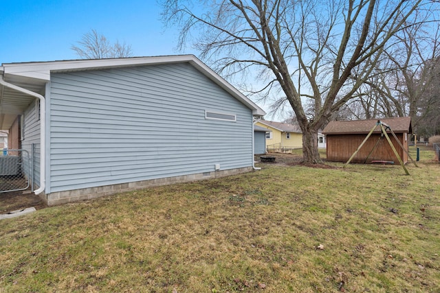 view of side of home with a yard and a storage unit