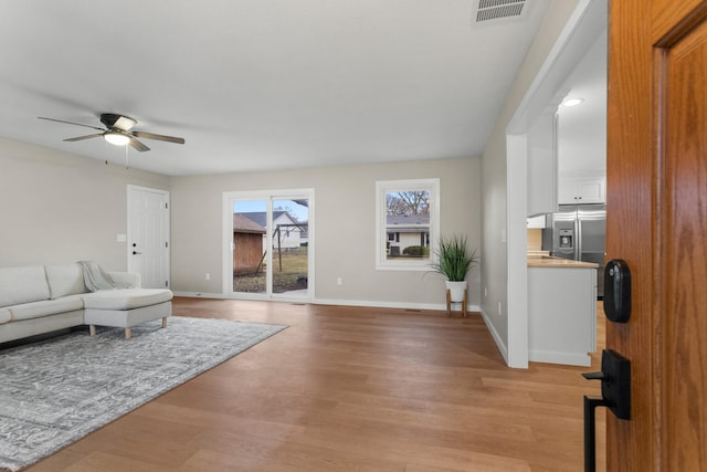 living room with light hardwood / wood-style floors and ceiling fan