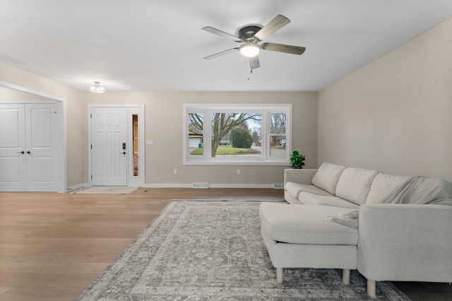 living room with ceiling fan and light wood-type flooring