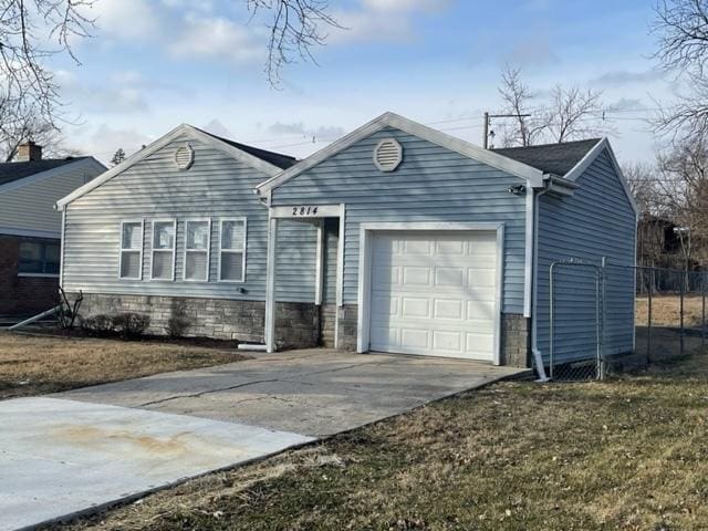 ranch-style home with a garage, fence, concrete driveway, and a front yard