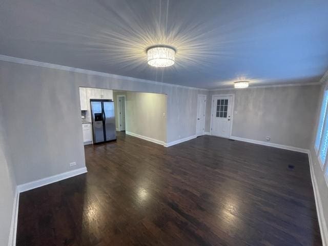 unfurnished room featuring ornamental molding, dark wood-style flooring, and baseboards