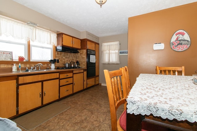 kitchen with sink, decorative backsplash, a textured ceiling, double oven, and stainless steel gas cooktop