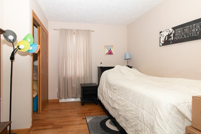 bedroom featuring wood-type flooring and a textured ceiling