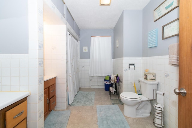 bathroom with vanity, toilet, and tile walls