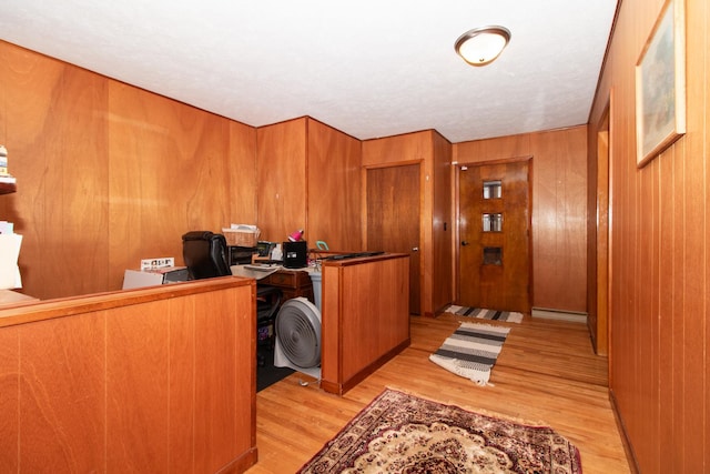 office space featuring wood walls and light hardwood / wood-style flooring