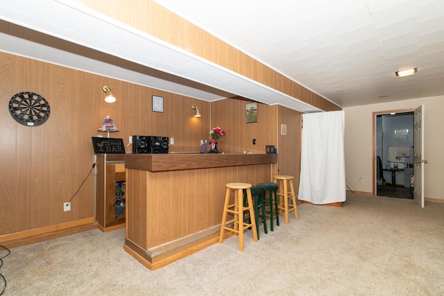 bar with light colored carpet and wood walls