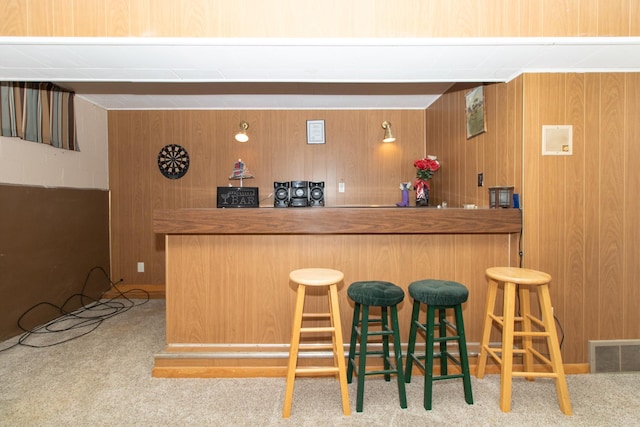 bar featuring wood walls and light colored carpet