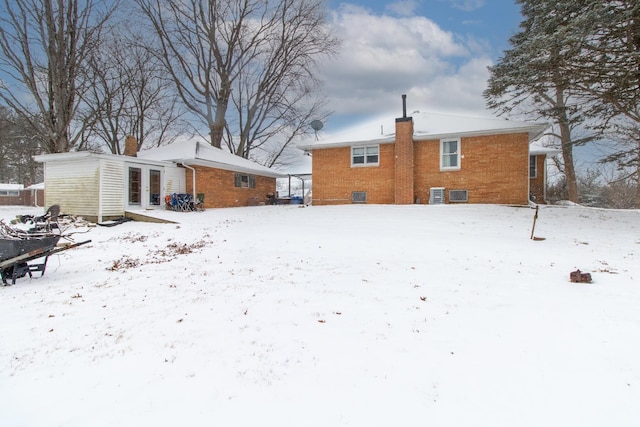 snow covered back of property featuring french doors