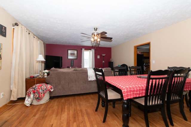 dining area with wood-type flooring, a textured ceiling, and ceiling fan