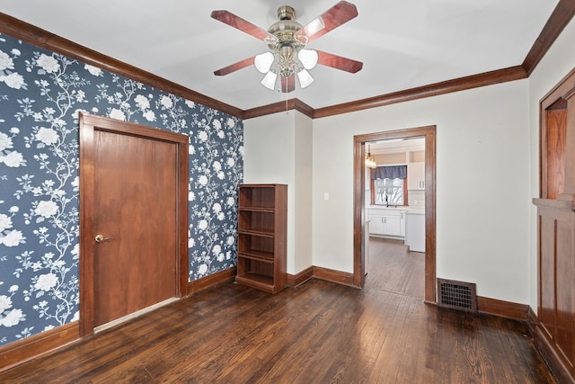 empty room featuring ceiling fan, dark hardwood / wood-style flooring, and crown molding