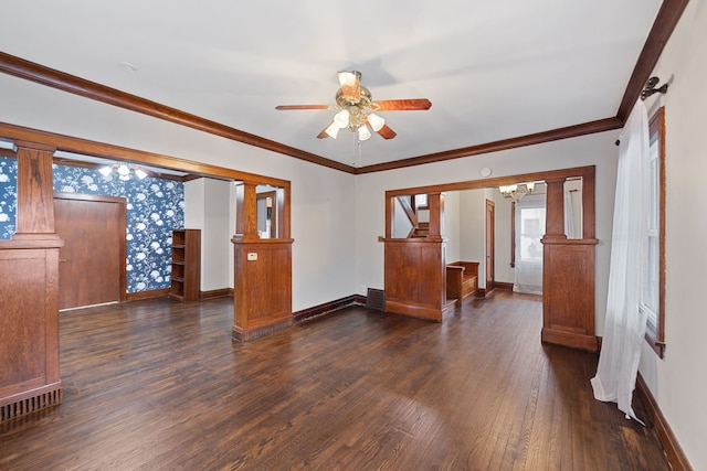 spare room with ceiling fan with notable chandelier, dark hardwood / wood-style flooring, ornamental molding, and decorative columns