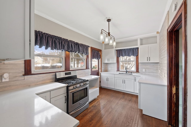 kitchen featuring pendant lighting, dark wood-type flooring, white cabinets, stainless steel range with gas cooktop, and decorative backsplash