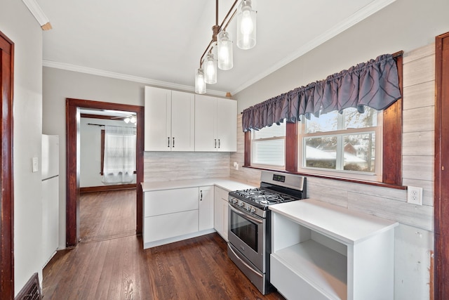 kitchen featuring dark hardwood / wood-style floors, white cabinetry, decorative light fixtures, and gas range