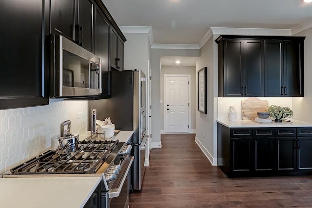 kitchen featuring decorative backsplash, appliances with stainless steel finishes, ornamental molding, and dark wood-type flooring