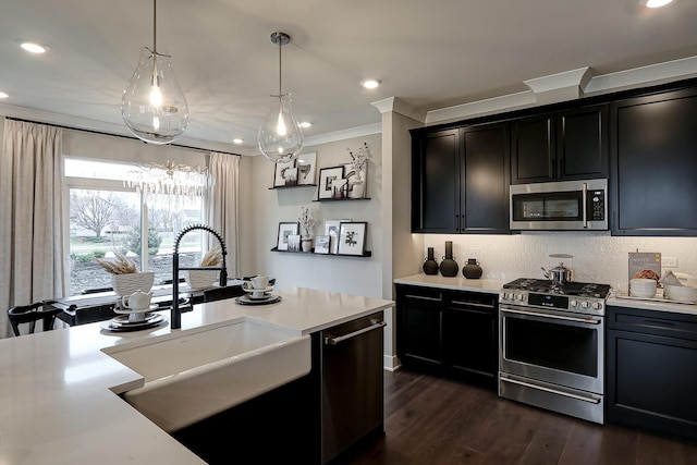 kitchen featuring sink, crown molding, hanging light fixtures, dark hardwood / wood-style floors, and appliances with stainless steel finishes