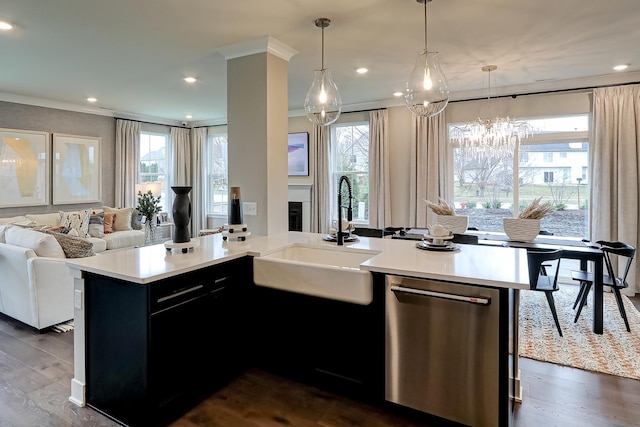 kitchen with a center island with sink, sink, stainless steel dishwasher, dark hardwood / wood-style floors, and decorative light fixtures