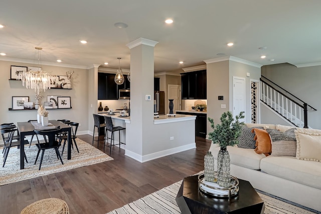 living room featuring a chandelier, crown molding, and dark wood-type flooring