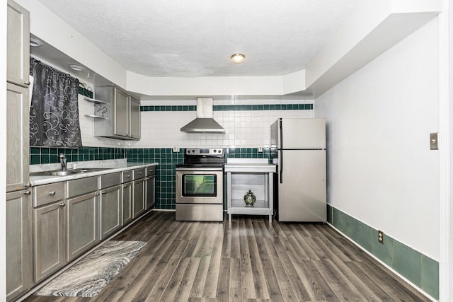 kitchen featuring sink, wall chimney exhaust hood, stainless steel appliances, dark hardwood / wood-style flooring, and a textured ceiling