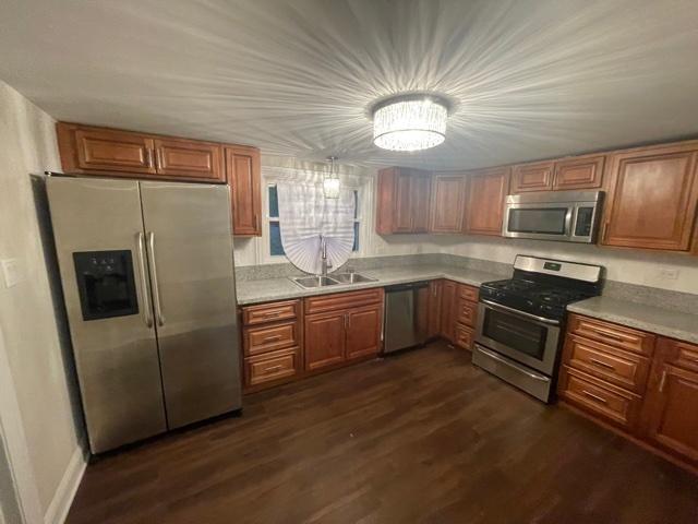 kitchen featuring brown cabinets, stainless steel appliances, and a sink