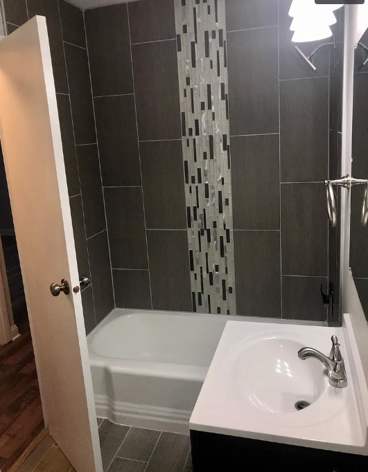 bathroom featuring shower / bath combination, wood finished floors, and vanity