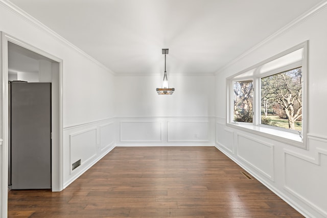 unfurnished dining area featuring dark hardwood / wood-style floors and ornamental molding