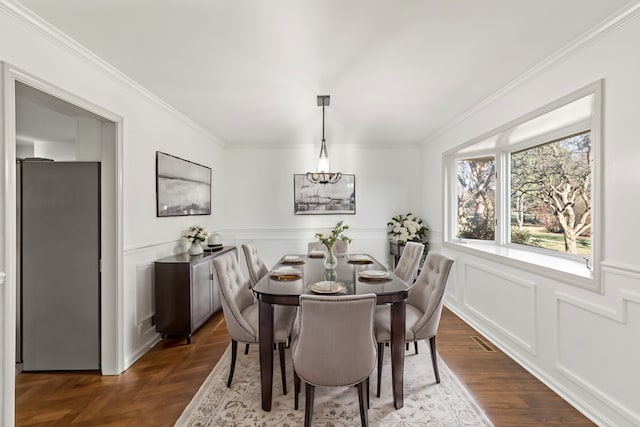 dining area featuring dark parquet floors and ornamental molding