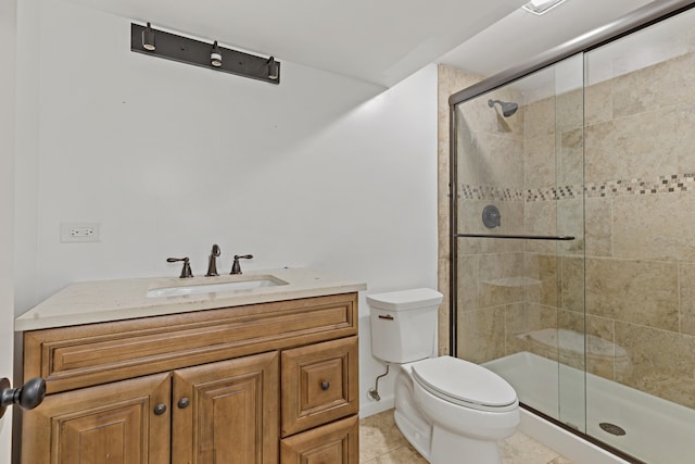 bathroom with toilet, vanity, tile patterned floors, and a shower with shower door