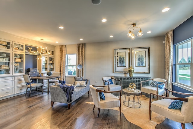 sitting room with built in features, hardwood / wood-style floors, an inviting chandelier, and plenty of natural light