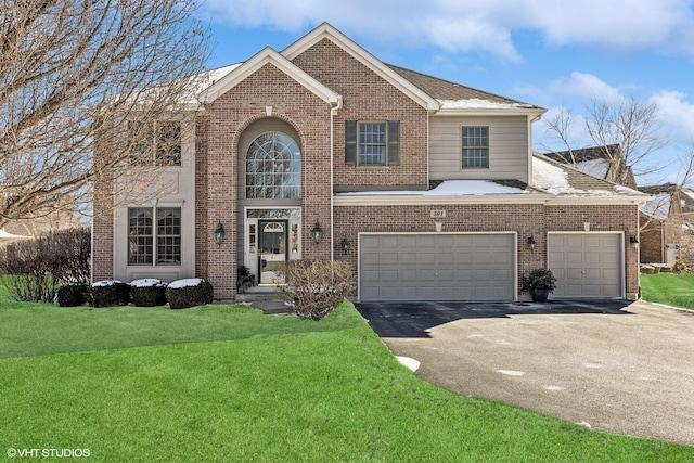 traditional home with brick siding, a front yard, and aphalt driveway