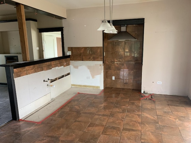 unfurnished dining area featuring tile walls