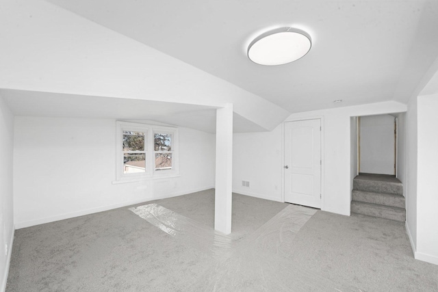 bonus room featuring vaulted ceiling and light colored carpet