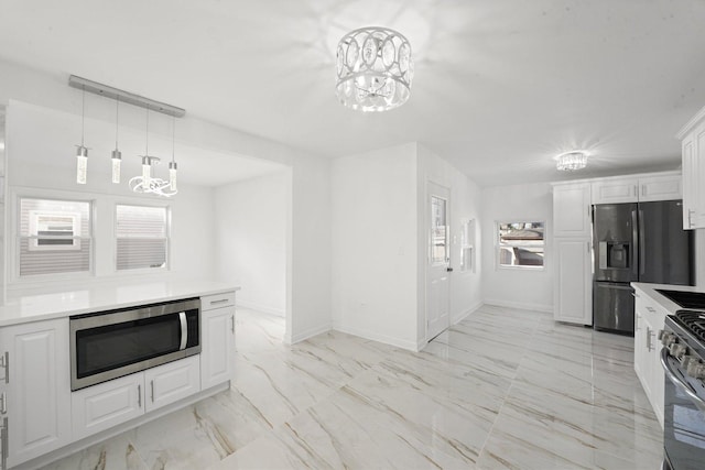 kitchen with white cabinetry, a notable chandelier, stainless steel appliances, and pendant lighting