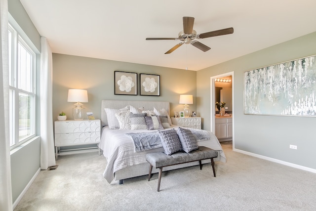 bedroom with ensuite bathroom, ceiling fan, and light carpet