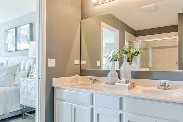 bathroom featuring a shower with door and vanity