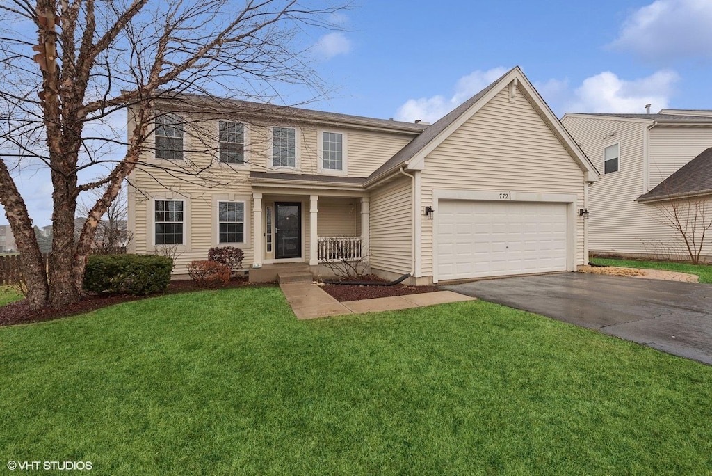 view of front facade with a garage, a front yard, and covered porch