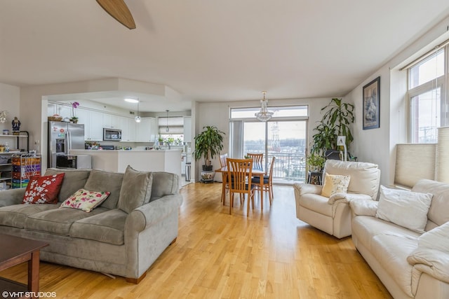 living room with a chandelier and light hardwood / wood-style floors