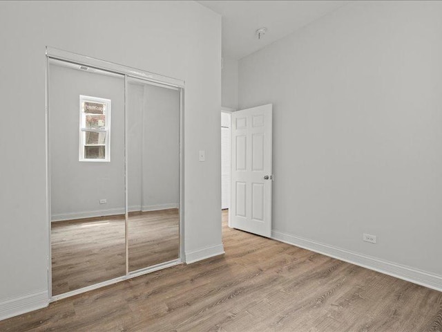 unfurnished bedroom with light hardwood / wood-style flooring and a closet