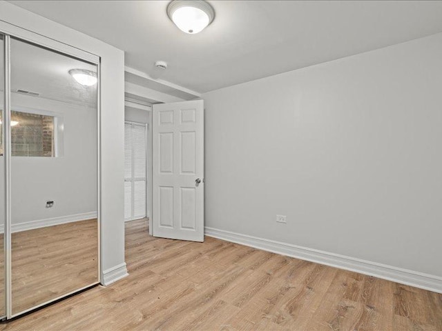 unfurnished bedroom featuring a closet and light hardwood / wood-style floors