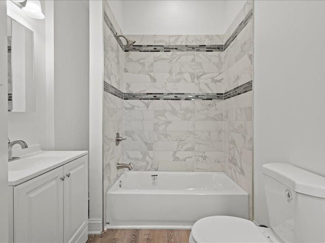 full bathroom featuring vanity, toilet, wood-type flooring, and tiled shower / bath combo