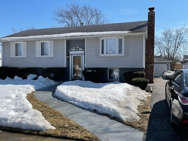 split foyer home featuring a garage and a chimney