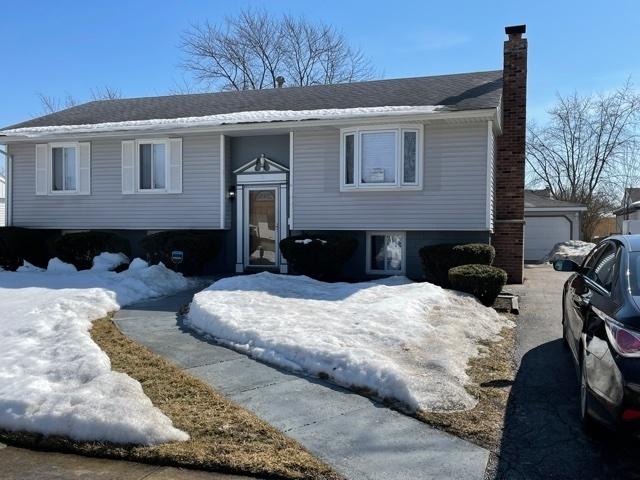 split foyer home featuring a garage and a chimney